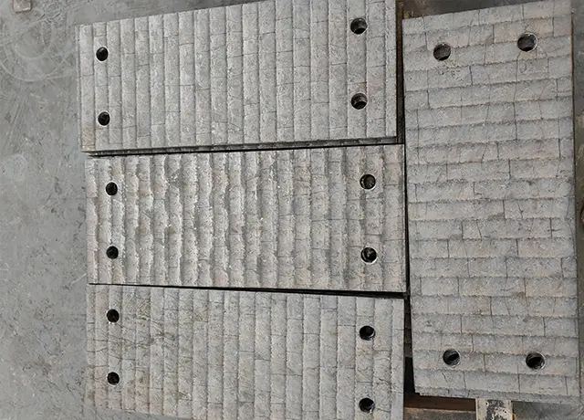 Drilled overlay liner plates for cement plant equipment